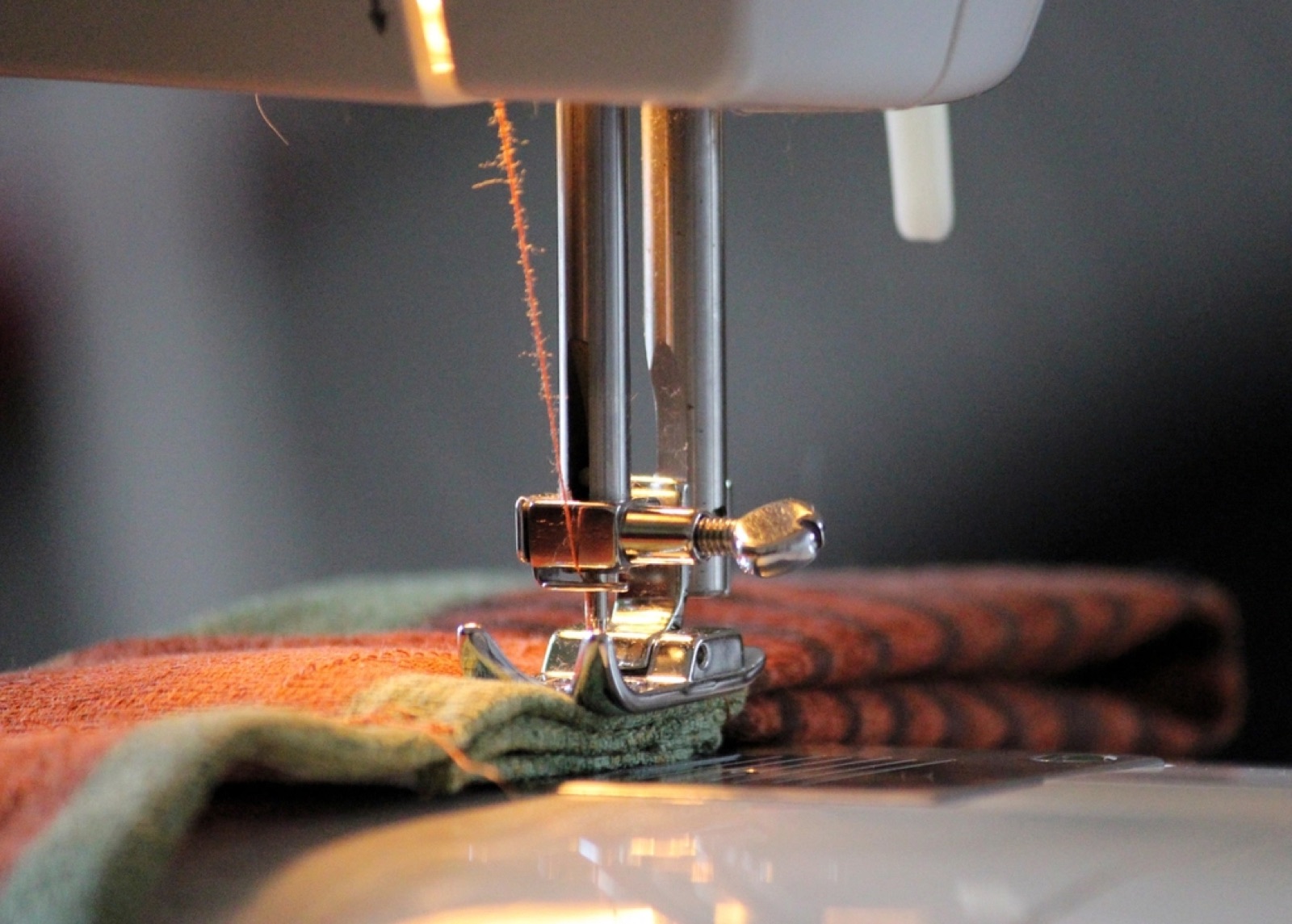 Sewing machine stitching together custom uniform fabric