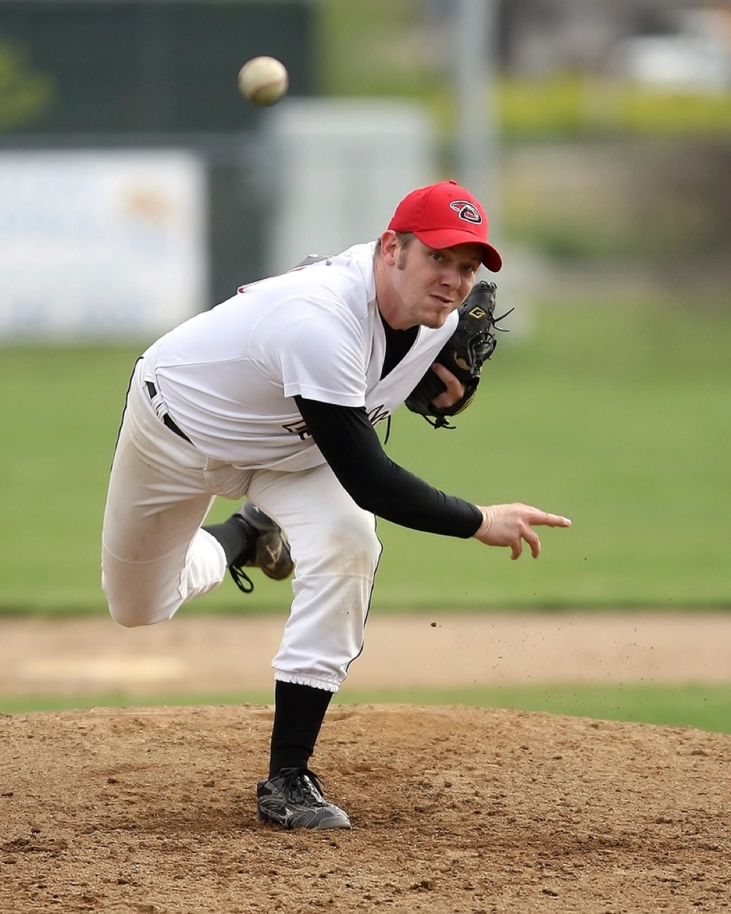 Baseball pitcher mid-throw on the mound