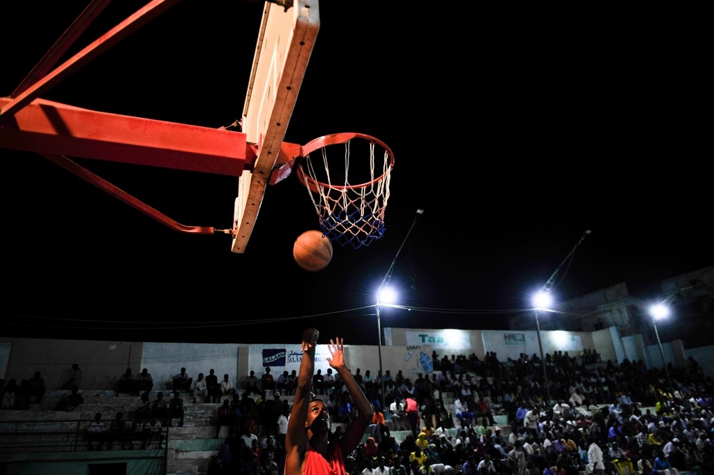 Basketball player shooting near the hoop under stadium lights